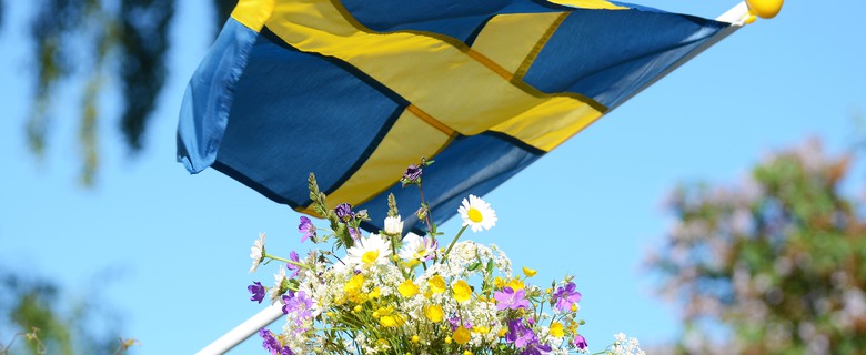 Svenska flaggan och en bukett sommarblommor.