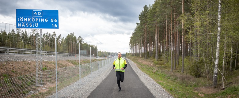 En man som springer vid en gång- och cykelväg