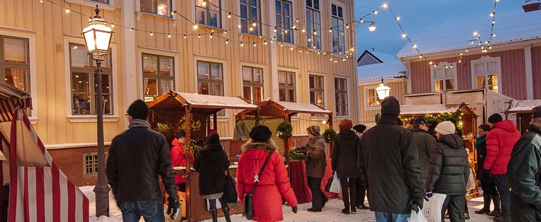 Julmarknadsbesökare på Lilla torget i Gamla stan i Eksjö. Gammaldags marknadsstånd och fina träbyggnader.