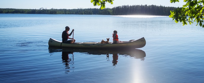 Bild på två personer som paddlar kanot.