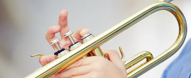 Ett barn spelar på en trumpet.
