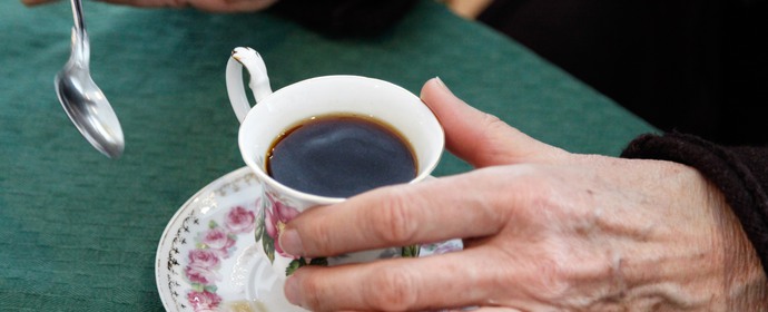 Närbild av en hand och en kaffekopp