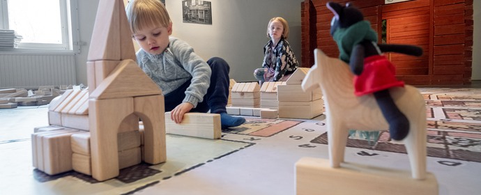 Barn som leker med klossar i stora utställningshallen på Eksjö museum