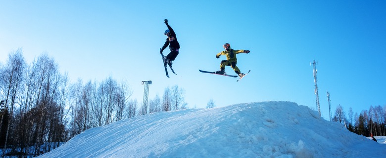 Två barn som hoppar i Valbackens slalomabacke.