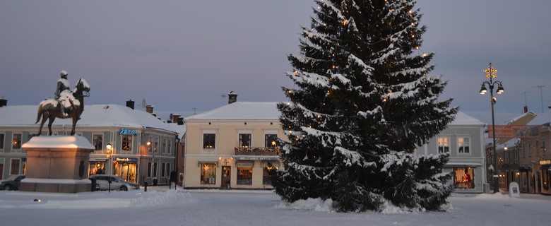Vy över Stora torget i Eksjö en vinterdag. En julgran lyser i förgrunden.