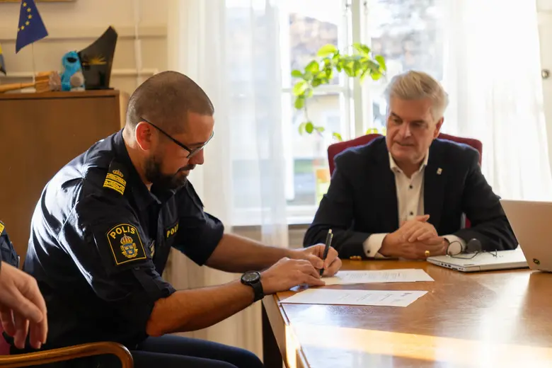 Lokalpolisområdeschefen Mathias Ljung och kommunstyrelsens ordförande Markus Kyllenbeck undertecknar medborgarlöftet.