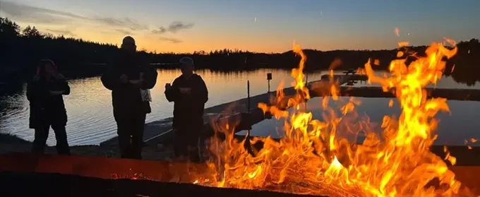 En grupp människor som står runt en eld.