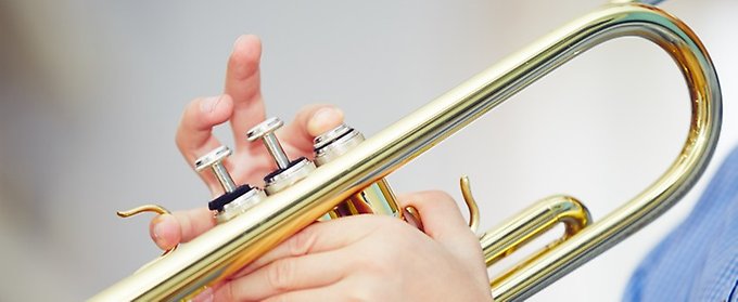 Ett barn spelar på en trumpet.